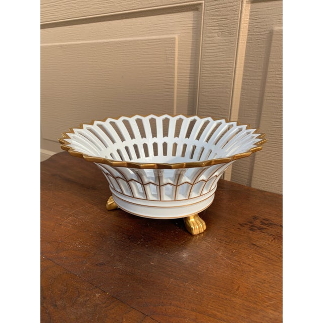 A refined reticulated porcelain basket, executed in a neoclassical idiom with delicate openwork and restrained gilt...