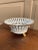A refined reticulated porcelain basket, executed in a neoclassical idiom with delicate openwork and restrained gilt...