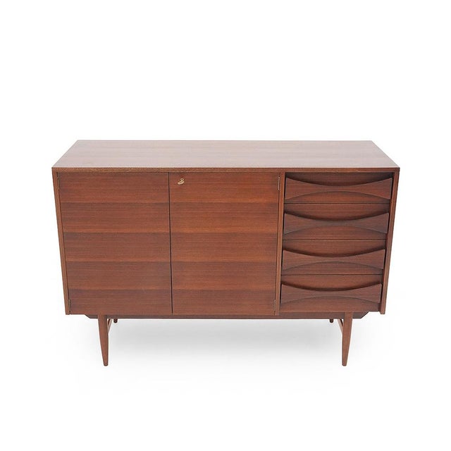 Italian mahogany-veneered sideboard from the 1950s, embodying a restrained modernism where disciplined design and...