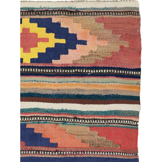 This mid-20th century Persian flatweave kilim rug beautifully reflects the bold geometry and expressive color sense...