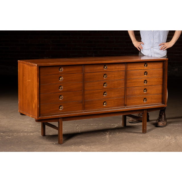 c. 1960s; United Furniture Corporation - Lexington, NC Mid-century walnut modern dresser featuring a clean architectural...