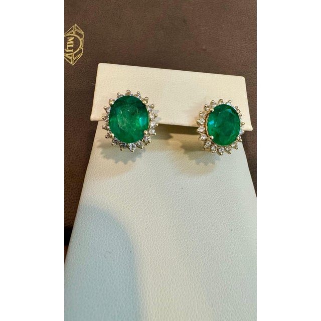 These exquisite post back earrings showcase a pair of natural oval-shaped emeralds weighing approximately 7 carats in...
