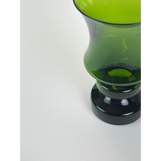 This mid-century modern green glass hooped vase was designed by Tamara Aladin for Riihimaki in Finland around the 1960s,...