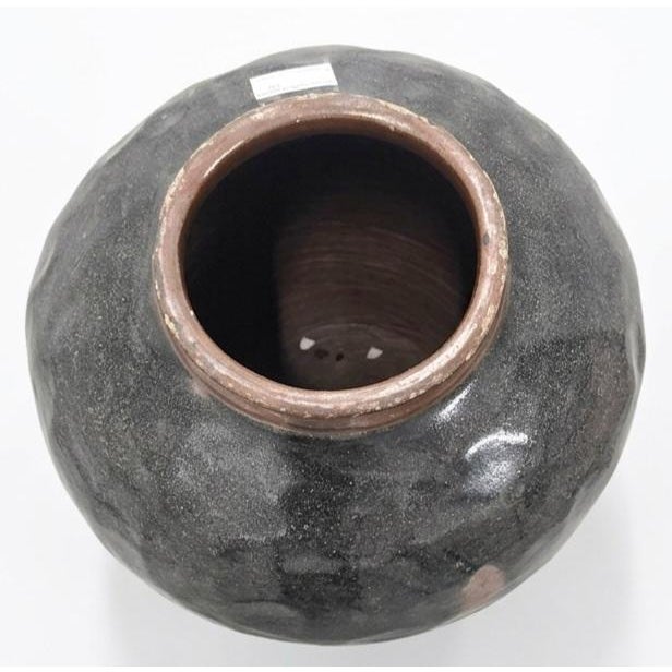 This vessel is a classic example of an antique Chinese stoneware storage jar styled after the utilitarian northern kiln...