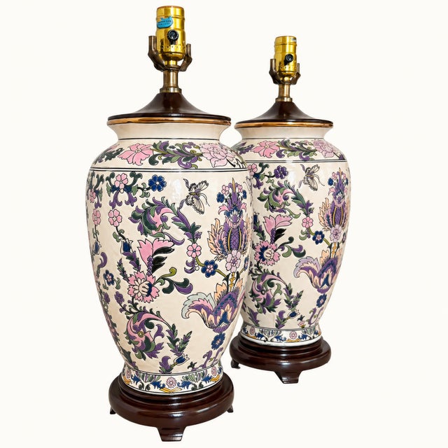 A striking pair of vintage ceramic urn or ginger jar table lamps featuring an exuberant allover botanical and butterfly...