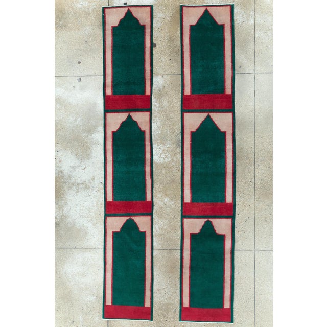 This pair of mid-20th-century Turkish Anatolian runners features a bold, simplified prayer-niche design arranged in three...