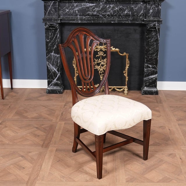 A Vintage Vintage Millinder Set of 4 Shieldback Chairs which will be the focal point of any space in which they are...