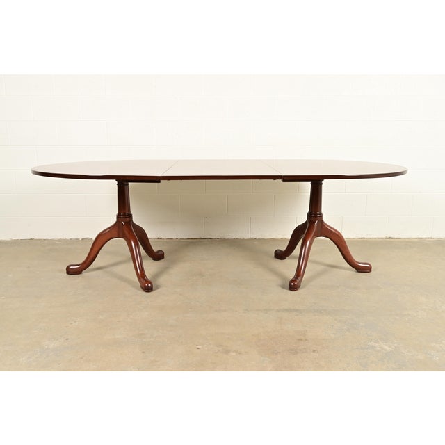 A gorgeous Georgian, Regency, or Queen Anne style solid mahogany double pedestal extension dining table By Kittinger,...