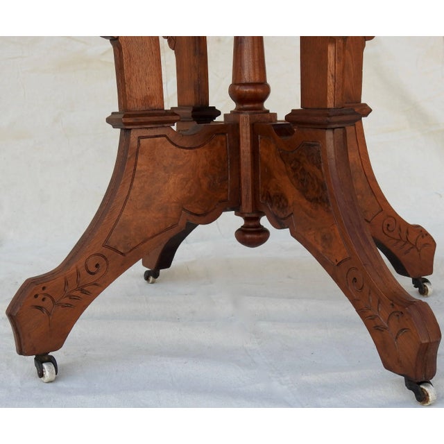 Burled walnut makes this Eastlake table a standout. It is Victorian from the late 19th century. The heavily carved wood it...