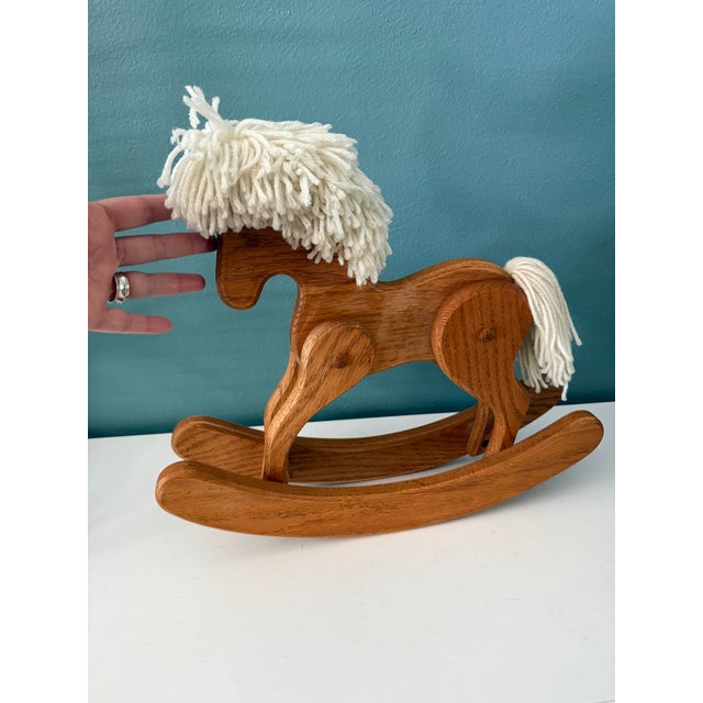 Charming vintage wooden rocking horse crafted from oak with a soft yarn mane and tail. The rocking horse has an unusual...