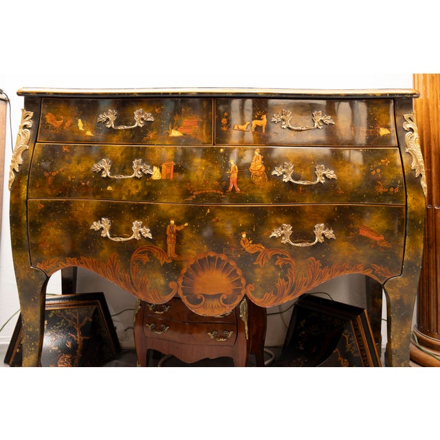 This is a very decorative French Louis XV style bombe chinoiserie commode lacquered overall. The painted top with gilt...