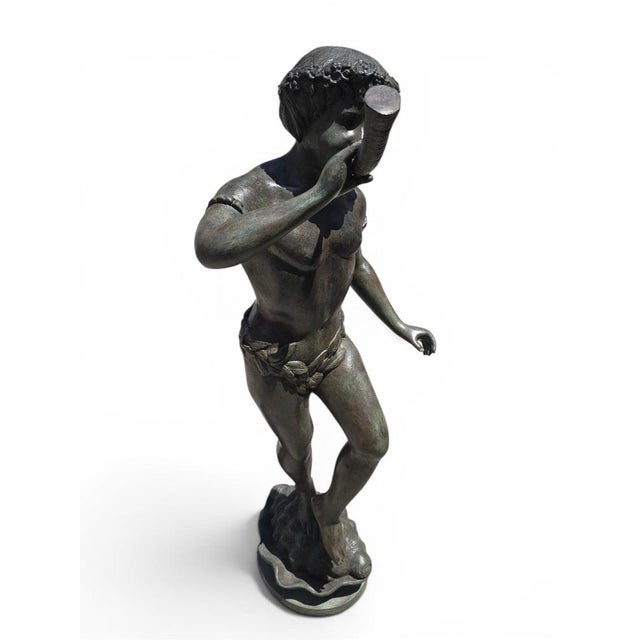 Charming and highly decorative bronze sculpture depicting a young boy blowing a horn while standing upon a sculptural...
