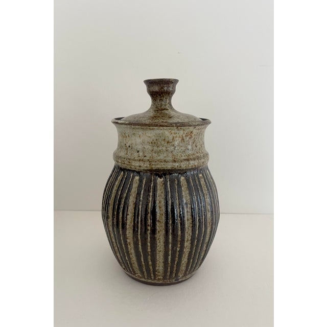 Mid-century handcrafted pottery jar. Shades of brown & taupe, with speckled and striped design.