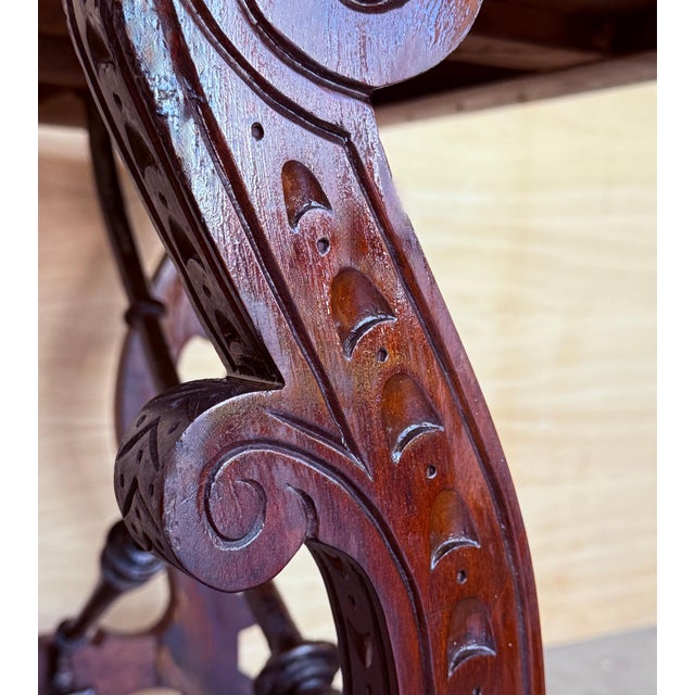 19th century Spanish trestle table in walnut. This piece has a great scale, lovely carved lyre legs and beautiful ebonized...