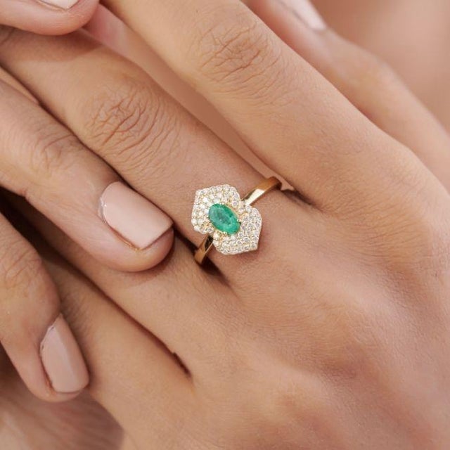 This Art Deco style ring features a 0.43 carat natural Zambian emerald, set in 14K yellow gold. The emerald measuring 6 x...