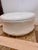 Round white faux alligator ottoman with a low, oversized form and chrome plinth base. Great glam/postmodern piece for use...