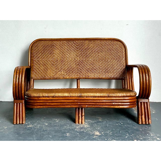 This charming vintage woven rattan loveseat is a refined example of mid-century craftsmanship, celebrating the era’s...