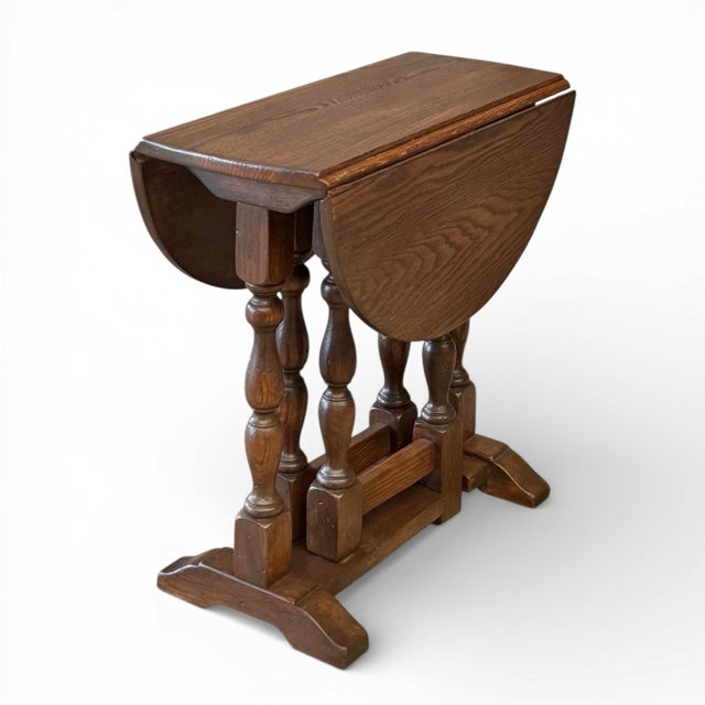 A mid-20th century William and Mary style dropleaf side table in solid oak having a gate-leg base supporting, when opened,...