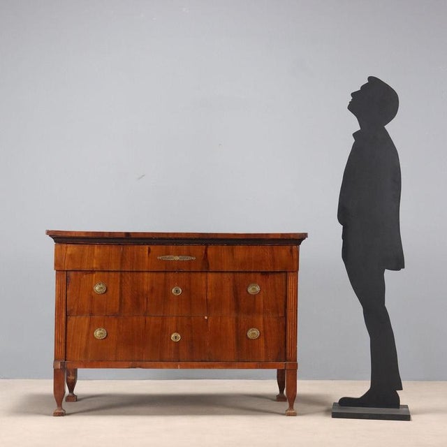 Empire mahogany chest of drawers. The front features three drawers, the first of which is slightly projecting, supported...