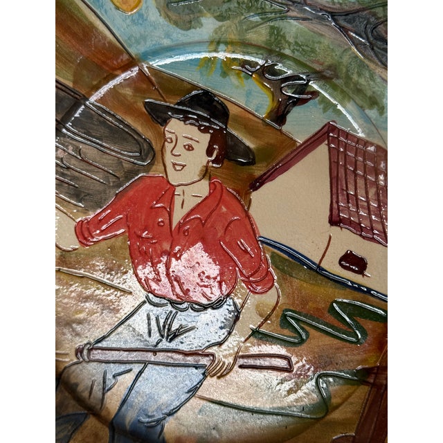 Rich in colour and rural charm, this hand painted ceramic wall plate was produced by Olaria Bulhão in São Pedro do Corval,...