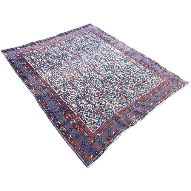 A beautiful antique Afshar rug, handwoven circa 1900 with an all over geometrical design of shrubs and flowers on an ivory...