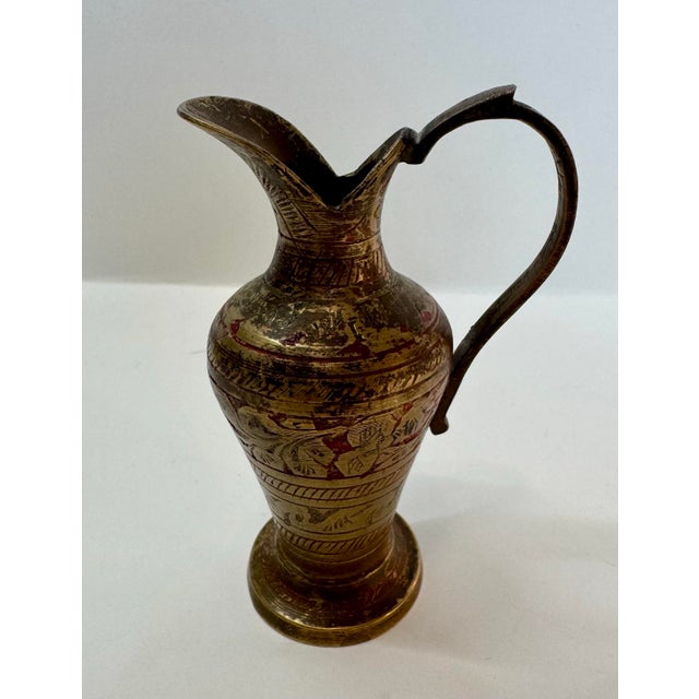 This curated collection features four distinct brass vessels, showcasing the intricate hand-crafted artistry of mid-...