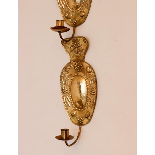 Made in Sweden A breath-taking mid-century pair of Swedish brass wall sconces, showcasing captivating hammered textures....