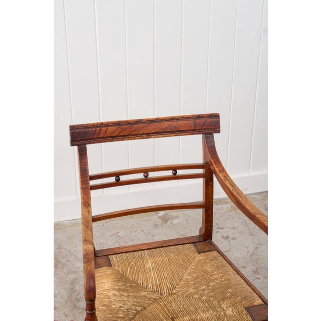 This single 19th-century ash and elm rush armchair has a warm-toned frame with handwoven rush seats. A gently curved top...