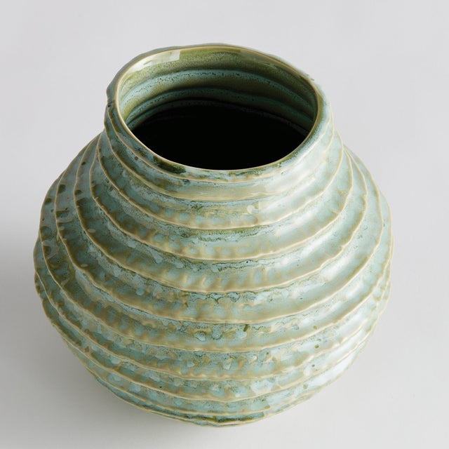 With a reactive glaze and hand finished ribbing detail, this charming sage green vase is a great find. Add a few faux...