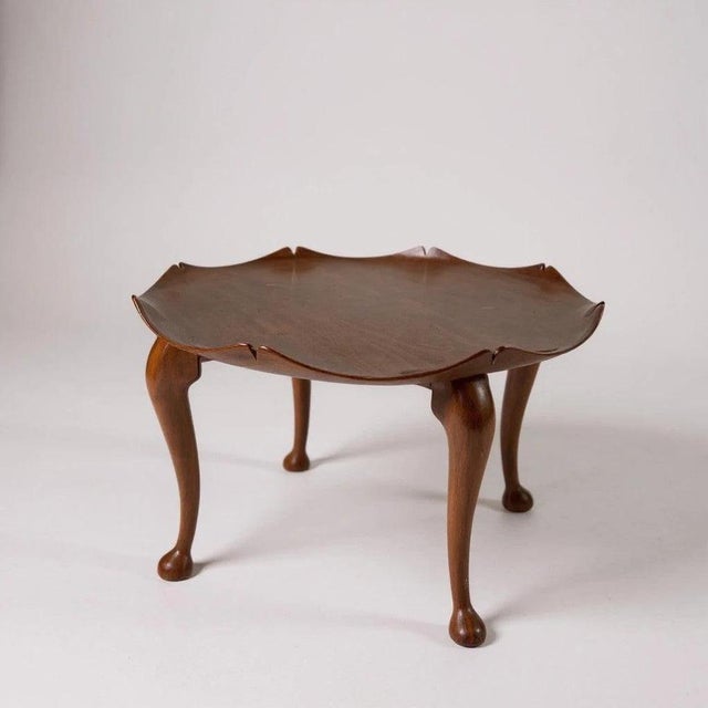 This teak coffee table from the early 1950s features a unique lotus leaf scalloped tabletop that brings mid century charm...