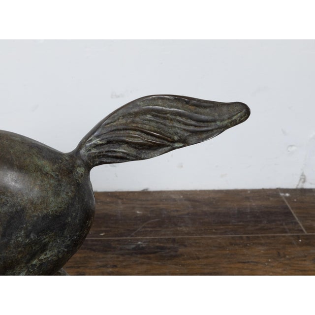 A small vintage bronze horse sculpture with dark patina and energetic pose. Discover the dynamic allure of this vintage...