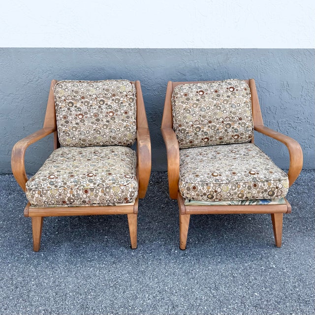 A distinctive pair of vintage mid-century modern lounge chairs attributed to Heywood-Wakefield, featuring sculptural...
