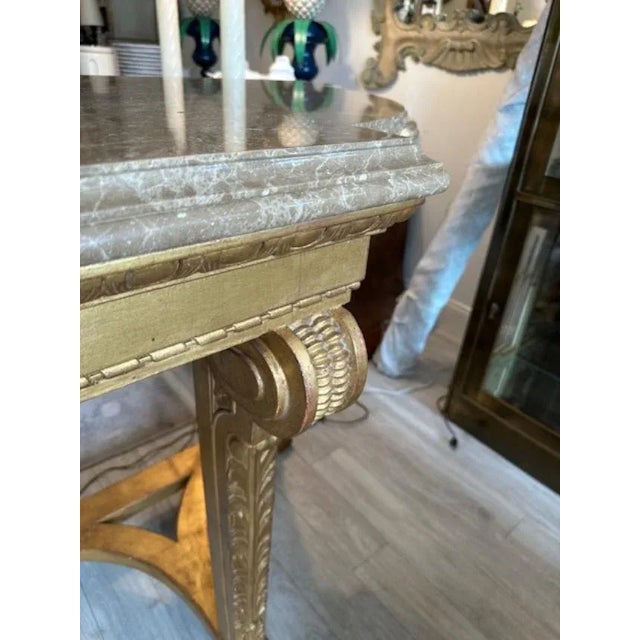 This is a Dennis and Leen Biennale Console in a custom size. Made of wood with a gilt finish and an ornately carved marble...