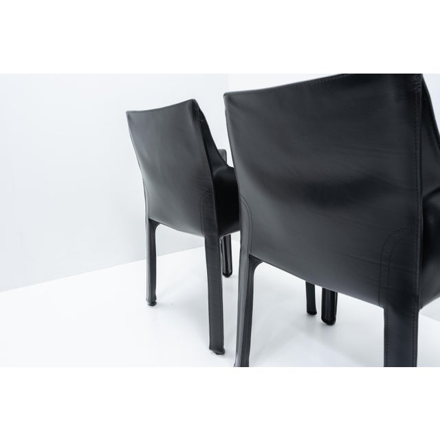 Cab 413 arm chairs in black leather by Mario Bellini for Cassina: The Cab chair is built up as a tubular frame over which...