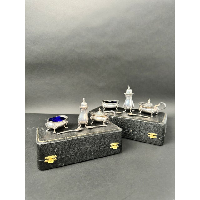 two cased silver cruet sets from Harrods London. A cruet set is a small set of containers for condiments like salt,...