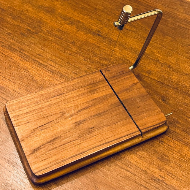 1970's Danish Modern style solid teak cheese cutting board with brass arm and adjustable cutter. Board surface 9.5" x...
