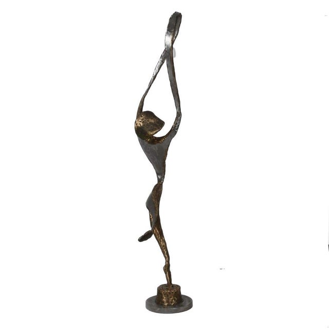 This striking modernist mixed metal sculpture depicts an abstract dancer captured in a moment of dynamic motion. The...