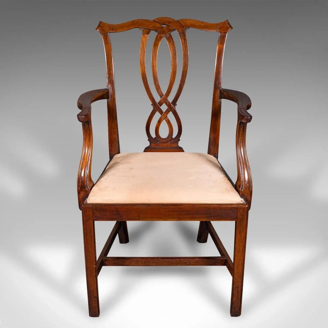 This is an antique drawing room elbow chair. An English, mahogany carver in Chippendale taste, dating to the Georgian...
