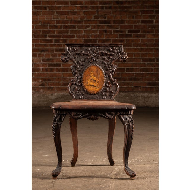 Exceptionally decorative Black Forest walnut valet chair combining seating and storage in a highly carved form. The back...