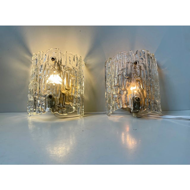Fagerlund Ice wall lights manufactured by Orrefors in Sweden during the 1960s. The textured crystal glass shading creates...