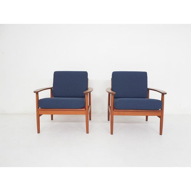About this item Teak lounge chairs with the orginal cushions with new dark blue fabric. The seating is with the original...