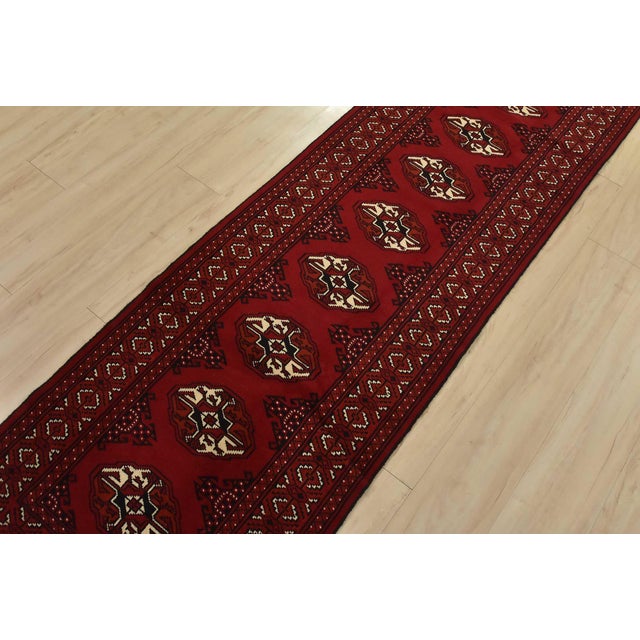 An authentic vintage tribal Turkmen runner, hand-knotted with fine wool and natural dyes. This nomadic rug features a row...