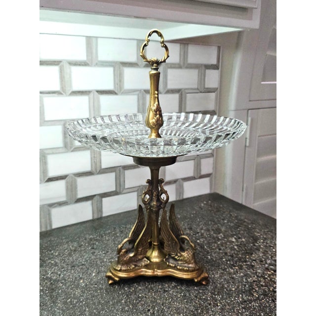 An exquisite vintage decorative fruit stand featuring an intricately detailed brass pedestal base adorned with four...