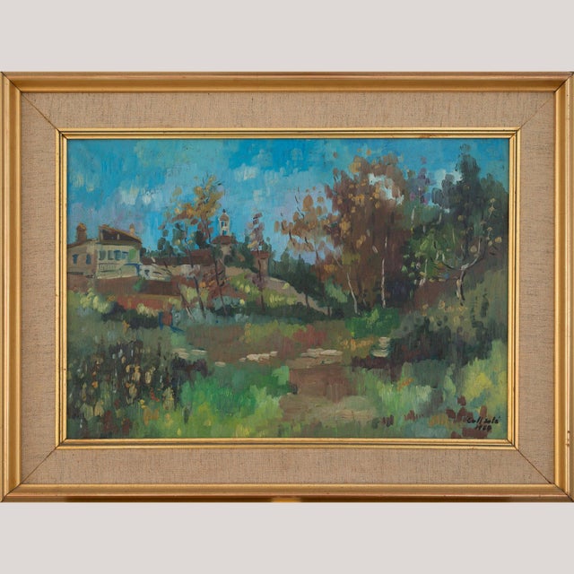 Oil on canvas portraying a village scene under a vivid blue sky, with a church tower rising above the trees and...