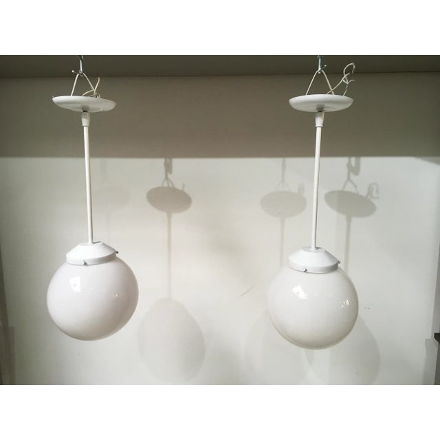 A sophisticated pair of mid-century modern pendant lights manufactured by the renowned Feldman Company of Los Angeles,...