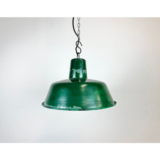 Industrial green pendant light made in Poland during the 1960s. White inside the shade. Iron top. The porcelain socket...