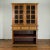 A large Indonesian cabinet from the early 20th century with beveled glass doors and three drawers. Created in Indonesia...