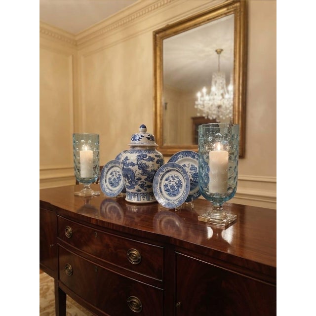 Elevate your tabletop or mantel decor with this striking pair of vintage glass hurricane candle holders. Rendered in a...