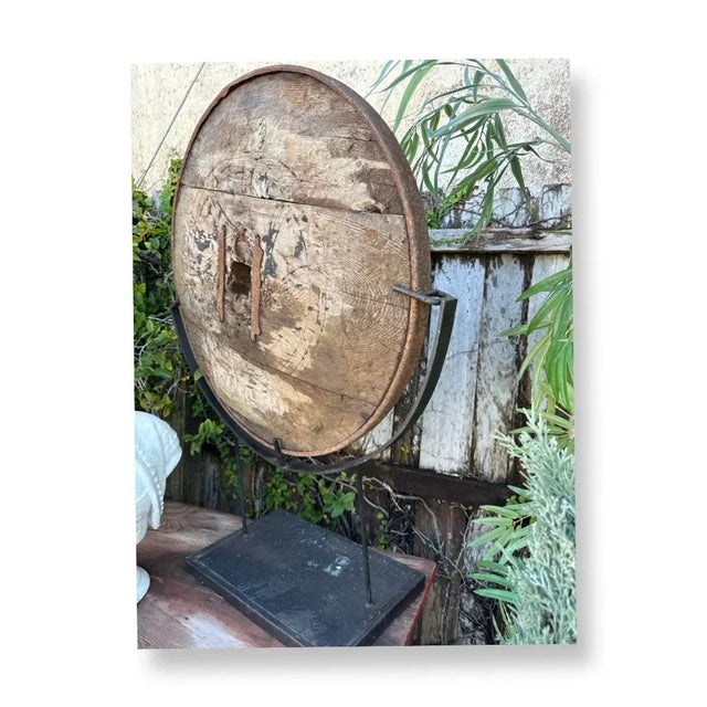 Very Decorative Antique carved wooden wagon wheel mounted on very strong iron base.