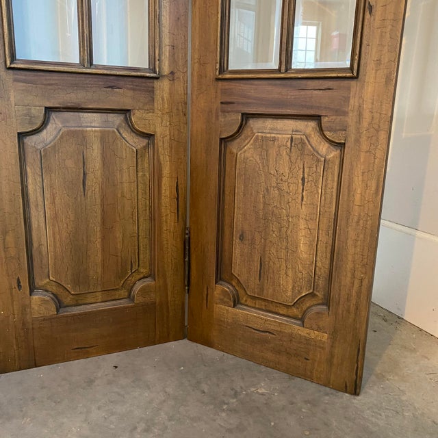 A striking antique French four-panel folding screen crafted in solid walnut with an elegant arched silhouette, glazed...